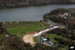 Water drains from the Guajataca Dam in Quebradillas, Puerto Rico, Sept. 23, 2017.