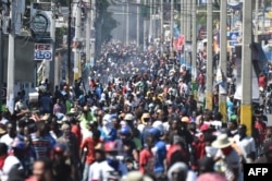 Demonstrators march on the streets on the fifth day of protests in Port-au-Prince, Feb. 11, 2019, against Haitian President Jovenel Moise and the misuse of PetroCaribe funds.