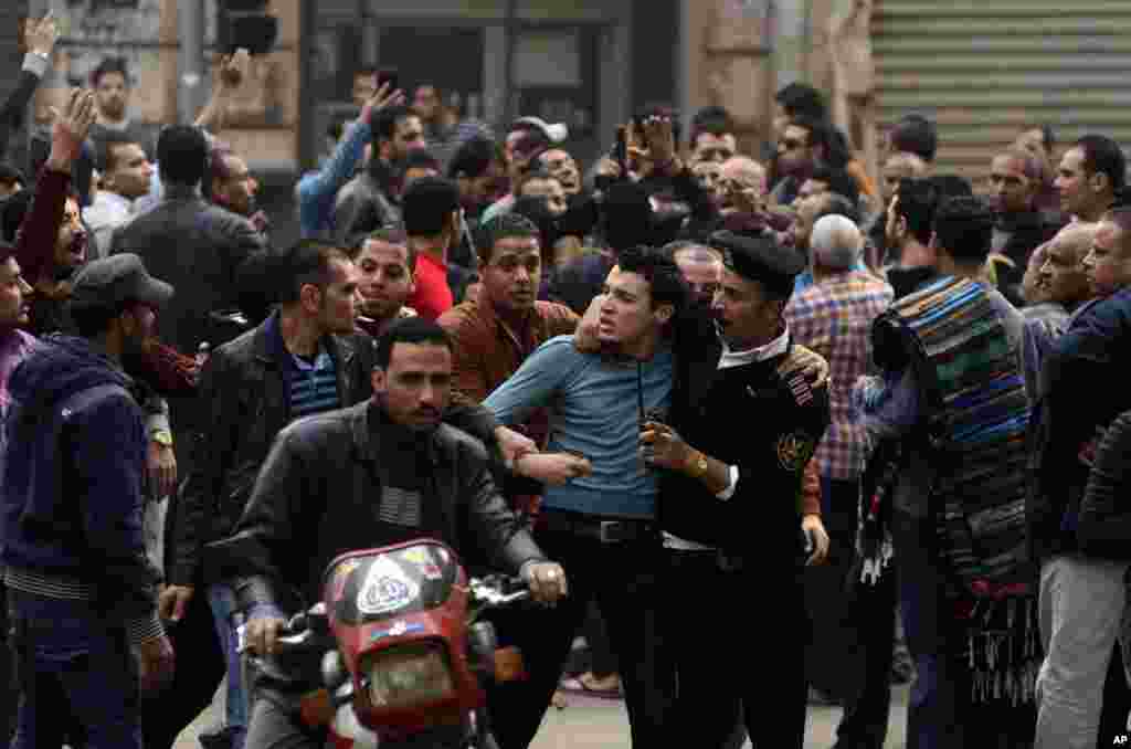 A supporter of Egypt&#39;s ousted President Mohamed Morsi is detained by police during clashes with security forces in downtown Cairo, Egypt.