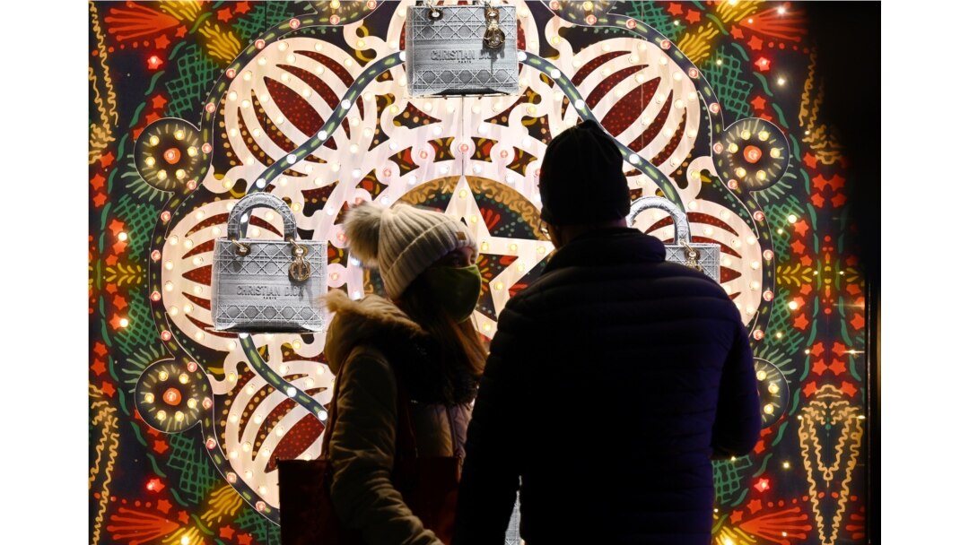 People wearing a face mask do some window shopping on Piazza di Spagna in central Rome on December 13, 2020, during the COVID-19 pandemic caused by the novel coronavirus. (Photo by Vincenzo PINTO / AFP)