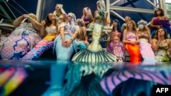 Mermaids dan Mermen bersiap untuk ambil bagian dalam renang terbuka saat berlangsungnya MerMagic Con di Freedom Aquatic Center, Manassas, Virginia, 7 Agustus 2021. (Joseph Prezioso / AFP)