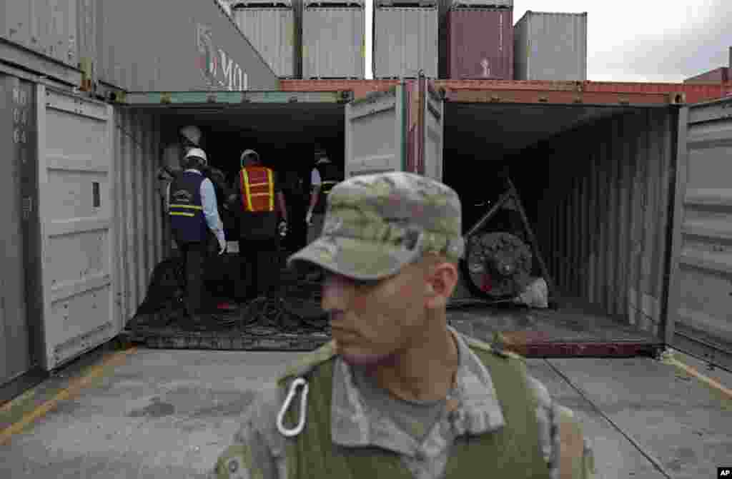 A police officer stands guard as investigation officers look inside a container holding military equipment aboard the North Korean-flagged freighter, Chong Chon Gang, at the Manzanillo International container terminal, Colon City, Panama.