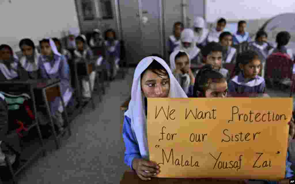 Pakistani girls display a poster while sitting at their desk, as their teacher, not shown, talks to them about&nbsp; Malala Yousafzai, Islamabad, Pakistan, October 12, 2012.