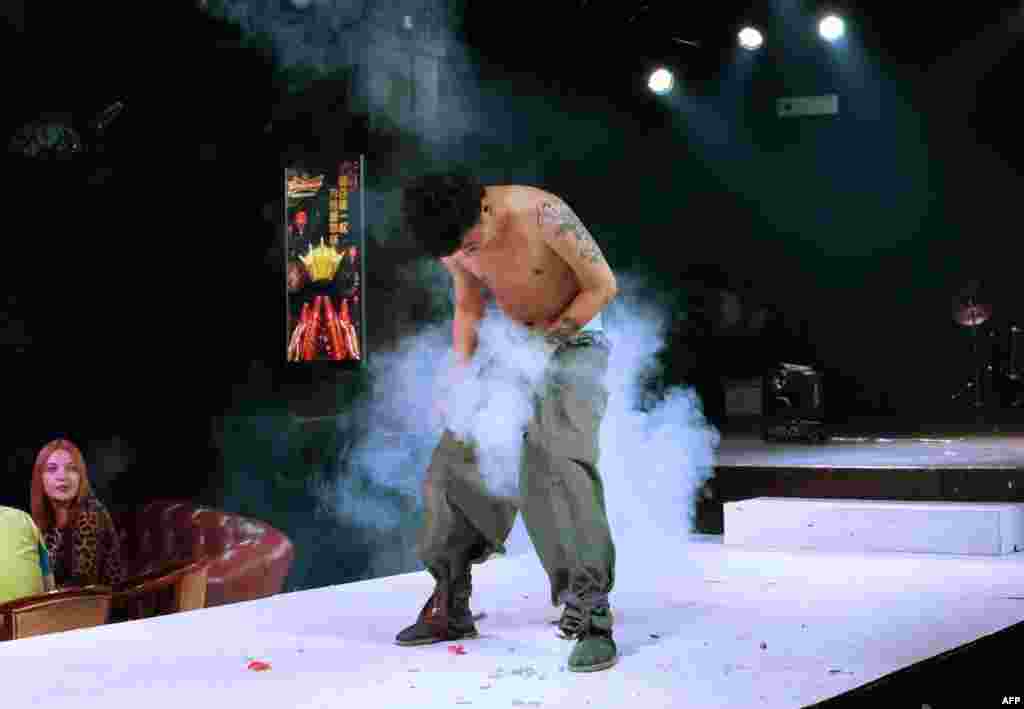 중국 지린성 훈춘의 한 술집 공연에서 출연자가 바지 속 불꽃을 터뜨리고 있다.