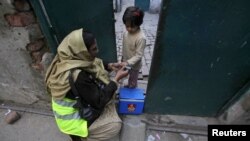 Petugas polio bernama Nishat memberikan vaksin polio pada seorang anak perempuan di Lahore, Pakistan (20/12). (Foto: Reuters)
