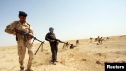 Members of Iraqi security forces take their positions during a patrol looking for militants of the Islamic State of Iraq and the Levant (ISIL) west of Kerbala, June 29, 2014. 