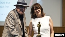Croatian Auschwitz survivor Branko Lustig and his wife Mirjana stand next to his Academy Award during a ceremony at Yad Vashem Holocaust memorial in Jerusalem, July 22, 2015.