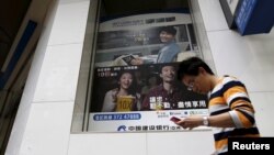一名香港男子从中国大陆银行-中国建设银行的广告前走过 （2015年11月30日）