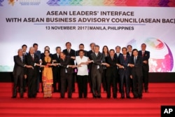 Philippine President Rodrigo Duterte, front center, links arms with heads of state and government participating in the ASEAN Summit in Manila, Philippines, Nov. 13, 2017.