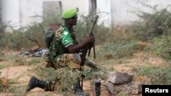 FILE - An African Union Mission in Somalia (AMISOM) peacekeeper from Burundi holds a position before being replaced by the Somali military at Jaale Siad Military academy in Mogadishu, Somalia. Feb. 28, 2019.