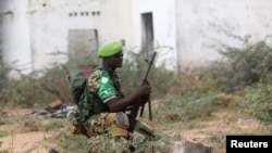 FILE - An African Union Mission in Somalia (AMISOM) peacekeeper from Burundi holds a position before being replaced by the Somali military at Jaale Siad Military academy in Mogadishu, Somalia. Feb. 28, 2019.