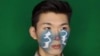 一名蒙古年轻人在脸上涂上蒙文“母语”连个字，抗议政府用汉语取代蒙文的教学计划。