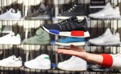 A shop assistant presents the new Adidas NMD model at the flagship store in Berlin, Germany, January 20, 2016.