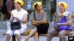 중국 상하이 등에서 기록적인 폭염이 계속되는 가운데, 31일 더위를 식히기 위헤 물수건을 머리에 얹은 주민들.