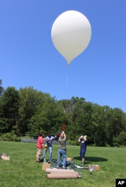 An 8-foot camera-carrying balloon rises into the sky during a test launch at the University of Hartford in West Hartford, Conn., Aug. 9, 2017. A team from the University of Bridgeport and the University of Hartford conducted the test as part a project that will send cameras into the stratosphere to photograph this month's solar eclipse.