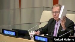 마이클 커비 전 위원장이 지난달 22일 유엔에서 열린 북한인권토론회에서 북한인권상황을 비판하며 COI 보고서를 들어 올리고 있다.