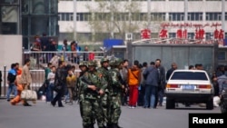 Paramilitary policemen stand guard near the exit of the South Railway Station, where three people were killed and 79 wounded in a bomb and knife attack on Wednesday, in Urumqi, Xinjiang Uighur Autonomous region, May 1, 2014.