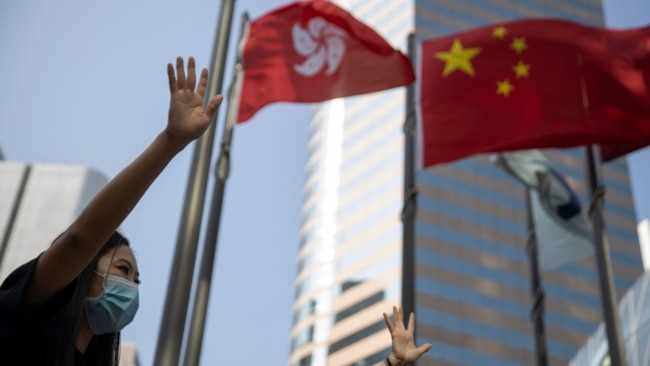 资料照：在香港和中国旗帜下香港抗议者伸出手掌表示五大诉求缺一不可。