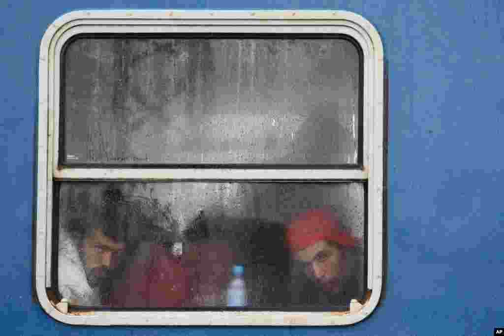 Migrants look out of the window a train at the railway station in Zakany, near the Croatian border, 230 kms southwest of Budapest, Hungary, after they were transported to the Hungarian border by Croatian authorities.