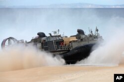 FILE - A U.S. Navy hovercraft approaches the beach at the beginning of a NATO Trident Juncture exercise at Raposa Media beach in Pinheiro da Cruz, south of Lisbon, Oct. 20, 2015.