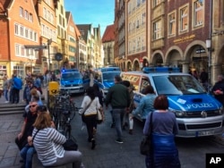 Police vans stand in downtown Muenster, Germany, April 7, 2018. German news agency dpa says several people killed after car crashes into crowd in city of Muenster.