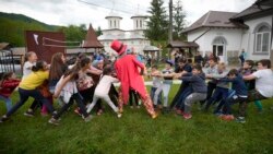 Children play during an eyesight examination performed by volunteer ophthalmologists, in Nucsoara, Romania, Saturday, May 29, 2021.