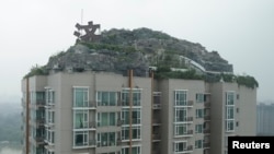 Privately built villa surrounded by imitation rocks atop a 26-story residential block, Beijing, Aug. 13, 2013.