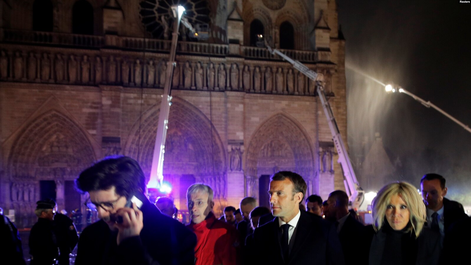 El presidente francés Emmanuel Macron y su esposa Brigitte a las afuera de Notre Dame mientras bomberos intentan contener el fuego. Photo: Reuters.