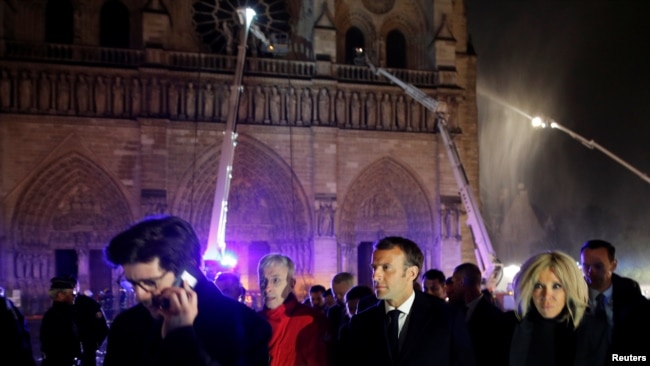 El presidente francés Emmanuel Macron y su esposa Brigitteen las afueras de Notre Dame mientras los bomberos intentan contener el fuego. Photo: Reuters.