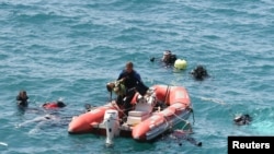 Một thợ lặn vớt một bé gái lên thuyền cứu hộ trong lúc các thợ lặn khác tìm kiếm các nạn nhân ngoài khơi vùng biển phía tây Thổ Nhĩ Kỳ, ngày 6/9/2012