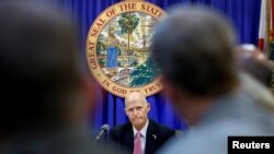 FILE - Florida Governor Rick Scott listens during a meeting with law enforcement, mental health, and education officials about how to prevent future tragedies in the wake the mass shooting at Marjory Stoneman Douglas High School, at the Capitol in Tallahassee, Florida, Feb. 20, 2018. 