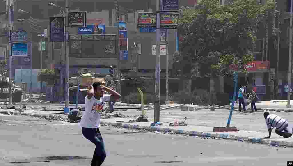 Seorang demonstran Mesir bereaksi setelah seorang pendukung presiden Mesir terguling Mohamed Morsi jatuh setelah ditembak pasukan keamanan. (AP/ Abdullah Shousha) 