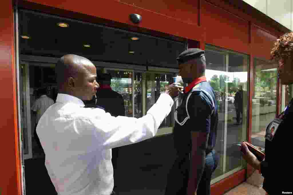 A security officer screens a man's temperature at the entrance of Transcorp Hilton hotel in Abuja, Sept. 3, 2014.