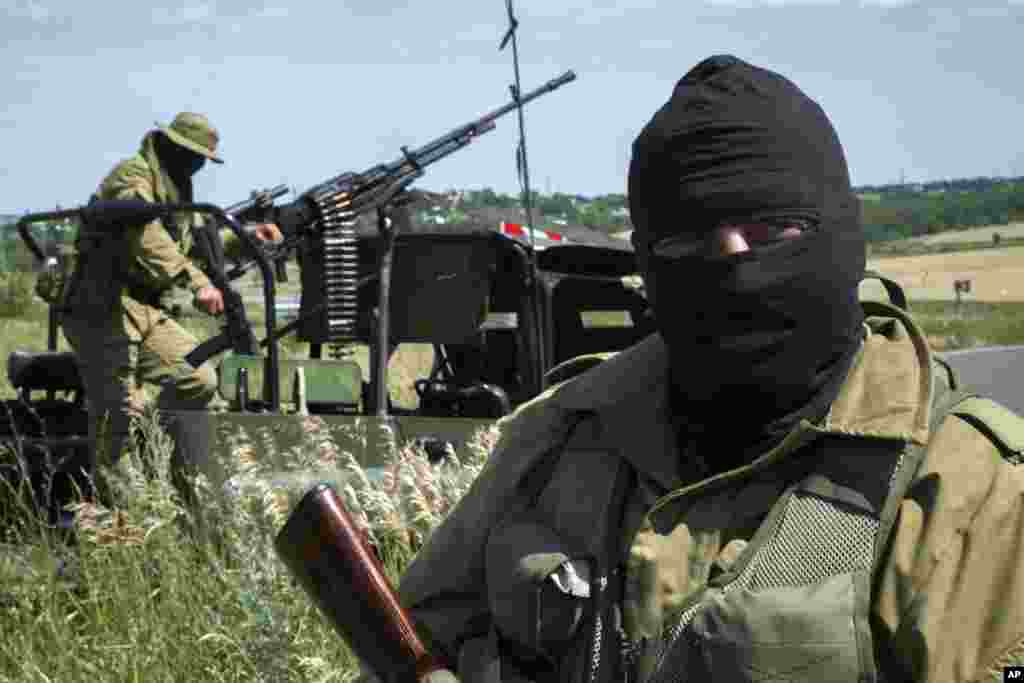 Pro-Russian fighters stand patrol near Luhansk, eastern Ukraine, July 2, 2014. 