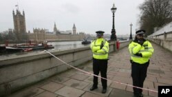 Polisi menjaga tanggul yang berbatasan dengan Gedung Parlemen Inggris (kiri), setelah serangan di London, Rabu, 23 Maret 2017. (AP Photo/Tim Ireland).
