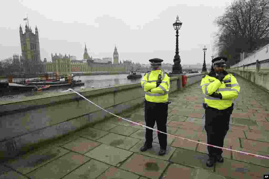 Police guard a cordon on the embankment with Britain's Houses of Parliament, left, in London, March 23, 2017, after attacks in London Wednesday. 
