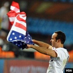 Landon Donovan melambaikan bendera AS setelah menang 1-0 atas Aljazair.