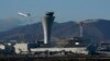 FILE - A plane takes off behind the air traffic control tower at San Francisco International Airport, in San Francisco, California, Nov. 24, 2020.