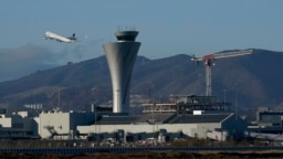 FILE - A plane takes off behind the air traffic control tower at San Francisco International Airport, in San Francisco, California, Nov. 24, 2020.