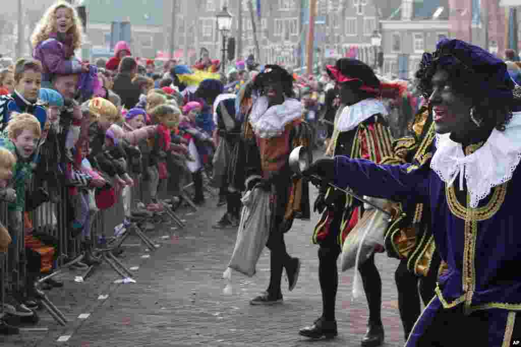 The Dutch version of Santa Claus, Sinterklaas, or Saint Nicholas, and his blackface sidekicks &quot;Zwarte Piet&quot; or &quot;Black Pete&quot; arrive by steamboat in Hoorn, north-western Netherlands, Nov. 16, 2013. The tradition is being debated, opponents say Black Petes are an offensive caricature of black people while supporters say Pete is a figure of fun whose appearance is harmless, his face soot-stained from going down chimneys to deliver present for the children.