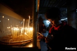 A visitor lights a candle inside the Church of the Nativity on Christmas in the West Bank town of Bethlehem, Dec. 25, 2016.