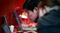 FILE - A man uses the free internet service at a commercial expo in Beijing, Feb. 26, 2011.