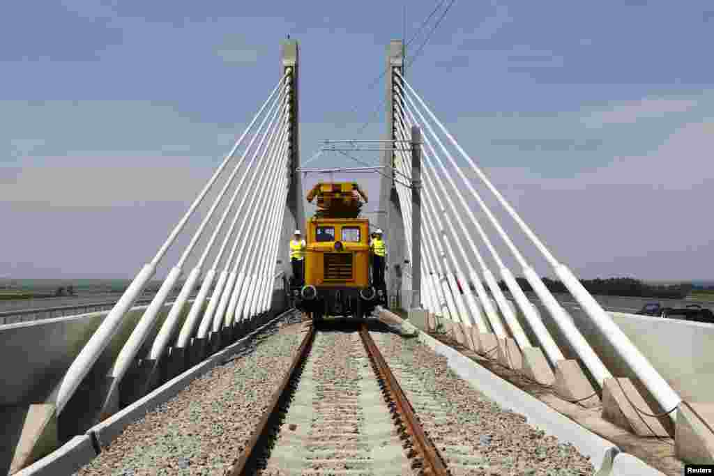 Sebuah kereta api melaju di atas jembatan yang baru dibangun di atas Sungai Danube, yang menghubungkan Calafat di Rumania ke Vidin di Bulgaria.