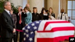 Miembros del público tomaron fotografías en sus teléfonos celulares mientras observaban el féretro del juez Antonin Scalia en el salón principal de la Corte Suprema en Washington, el viernes, 19 de febrero de 2016.