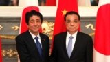 日本首相安倍晋三在东京与到访的中国总理李克强握手。（2018年5月9日）