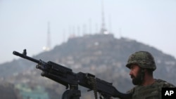 FILE - An Afghan soldier stands guard at the site of a suicide attack by the Taliban in Kabul, Afghanistan, Saturday, Dec. 13, 2014.