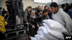 (FILE) A Palestinian man transports sacks of humanitarian aid at the distribution center of UNRWA in Rafah in the southern Gaza Strip on March 3, 2024.