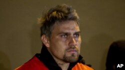 Suspended first-division soccer goalkeeper Omar 'El Gato' Ortiz, arrested for alleged participation in a kidnapping ring, is guarded by state police during a presentation to the press in Monterrey, Mexico, January 7, 2012.