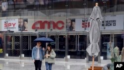 FILE - People exit an AMC theater Saturday, March 14, 2020, in Los Angeles. Californians wanting to escape the new reality of the coronavirus at the movies, casino or amusement park are running into the six-foot rule. 