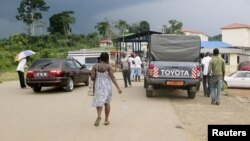 FILE - People wait to cross the border into Equatorial Guinea by car and by foot in Kye-Ossi, Cameroon, May 23, 2015. 